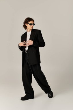 Yakışıklı genç adam, minimalist bir arkaplana karşı şık bir şekilde poz veriyor..