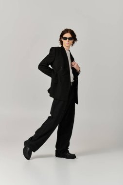 Şık bir genç adam kendine güvenerek, modaya uygun kıyafetlerini ve çekiciliğini sergiliyor..