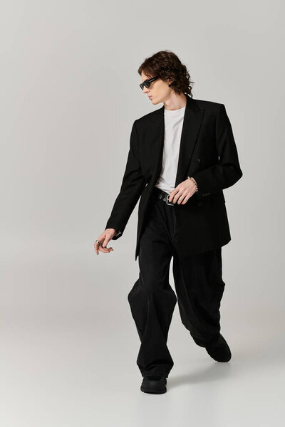 Молодой красивый мужчина демонстрирует современный стиль во время прогулки грациозно на обычном фоне.