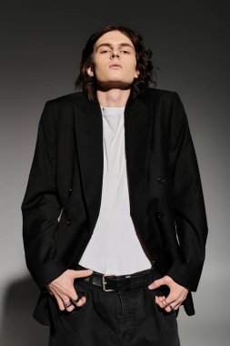 Şık bir genç adam şık bir siyah ceket ve minimalist kıyafete güvenir..