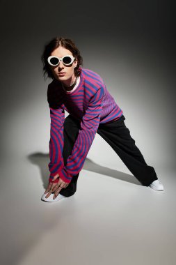 Çekici bir genç adam, modaya uygun giyinip, modern bir hava yayıyor..