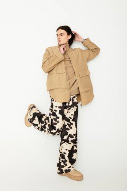 Şık bir genç adam dikkat çekici bir doku ve şablon karışımında kendine güvenerek poz verir..