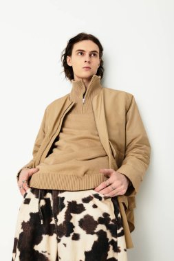 Yakışıklı ve modaya uygun genç bir adam şık kıyafetini kolaylıkla sergileyerek ayakta duruyor..