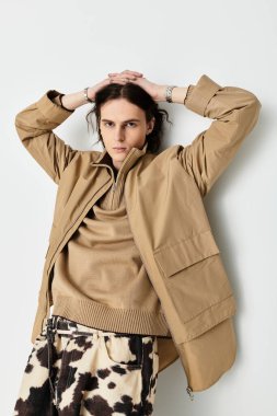 Yakışıklı genç bir adam modern uzayda rahat bir pozla modaya uygun kıyafetlerini sergiliyor..