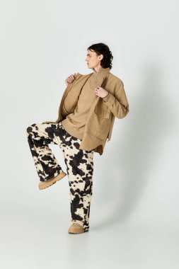 Yakışıklı genç adam modern bir ortamda çağdaş moda tarzını sergiliyor..