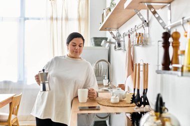 A young woman brews coffee in a cozy kitchen, savoring a peaceful moment of relaxation. clipart