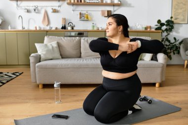 Rahat aktif giyimli genç bir kadın evde esneme hareketleri yapıyor, spor salonuna odaklanıyor..