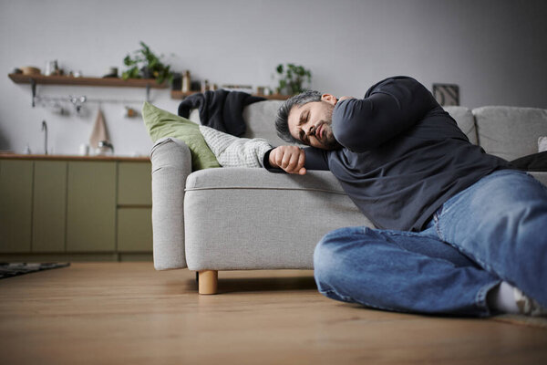 A handsome man relaxes on the couch, enjoying a cozy, peaceful afternoon.