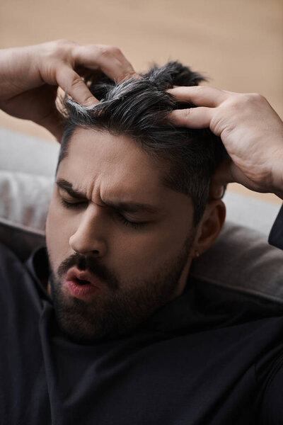 A handsome man with a thoughtful expression, lost in contemplation and emotion.