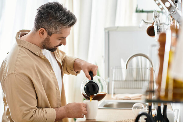 Очаровательный момент разворачивается, когда стильный мужчина наливает свежий кофе в кружку на своей уютной кухне.
