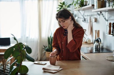 Güneş ışığı ve yeşilliklerle dolu sıcacık bir mutfakta bir kadın depresyon duygularıyla boğuşuyor..