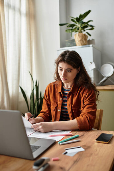 Женщина глубоко в мыслях, задумчиво пишет за своим столом в окружении зелени и естественного света