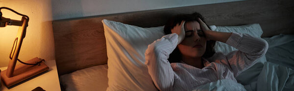 Женщина борется со своим чувством грусти и безнадежности, отдыхая ночью в постели..