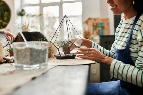 Woman at a sunny workshop to craft beautiful succulent terrariums.