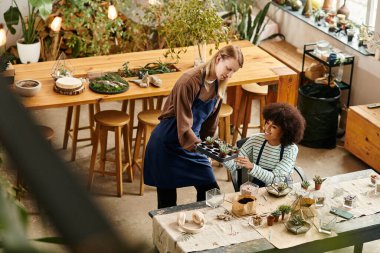 Canlı bir atölyeye katılanlar, lezzetlilerle çalışırken dostluk ve yaratıcılıklarını paylaşıyorlar.