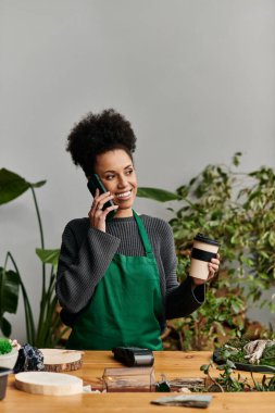 Canlı yeşil bir ortamda telefon ve kahveyle şık bir kadın..
