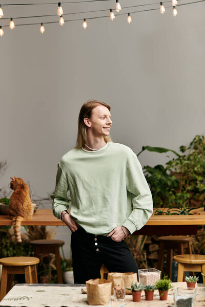 Joyous long haired man in stylish attire in workshop studio.
