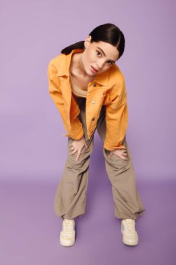 Kendine güvenen genç bir kadın modaya uygun şehir kıyafetleri içinde şık görünümünü sergiliyor..