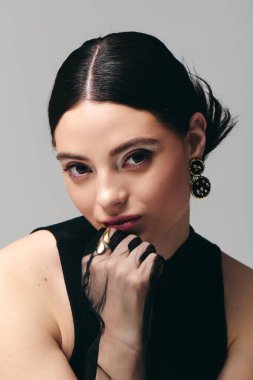 Genç bir kadın zarif tarzını ve moda anlayışını sergileyerek kendine güvenerek poz verir..