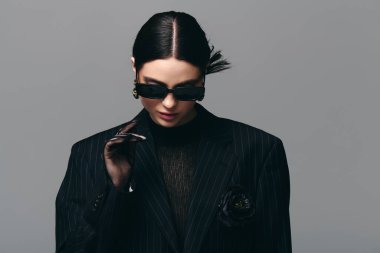 Zarif bir kadın zarif siyah bir elbise içinde zarifçe poz verir, zarafet ve zarafet saçar..