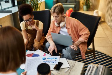 Colleagues engaged in a focused discussion, analyzing reports and graphs in a hotel setting. clipart