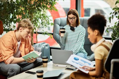 Three colleagues engage in discussions while working on laptops in a hotel lounge, enjoying coffee. clipart