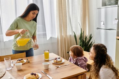 İki anne kızlarıyla sabah yemeğinden zevk alır, birlikte neşeli anlar yaratırlar..