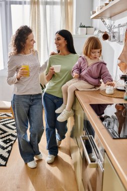 Kızları mutfağı keşfederken iki kadın sıcak bir sohbet ediyor..