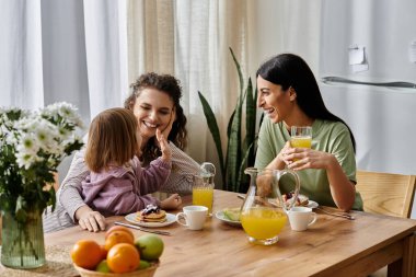 İki kadın güzel bir kahvaltı sırasında kızlarıyla keyifli anlarını paylaşıyor..