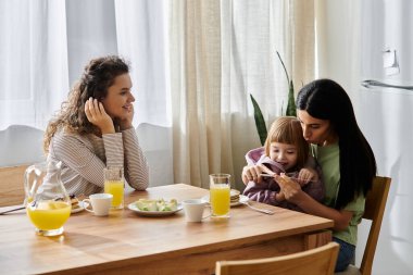 İki kadın kahvaltıda kızlarıyla mutlu mesut bir şekilde nişanlanıyor..