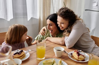 Neşeli bir aile, neşeli bir kahvaltı sırasında kahkaha ve krep paylaşır..