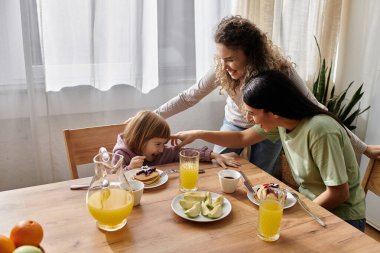 İki kadın kahvaltıdan zevk alırken kızlarıyla neşeyle nişanlanıyor..