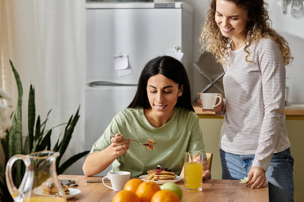 Две счастливые женщины наслаждаются восхитительным завтраком вместе, разделяя смех и любовь.