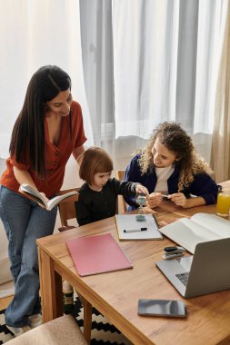 İki annenin yaratıcı faaliyetlerinde kızlarını desteklediği neşeli bir aile anı..