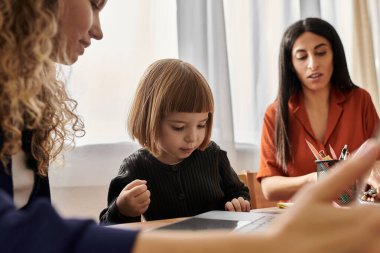 İki anne, kızlarıyla mutlu anlarını paylaşan parlak, modern bir dairede buluşur..