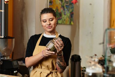 Güzel bir kişiliği olan genç bir kadın bir kafe ortamında gülümserken malzemeleri karıştırır..