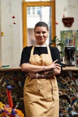 Genç bir kadın enerjik kişiliğini sergilerken, parlak gülümsemeler ve sıcak ortam kafeyi dolduruyor..