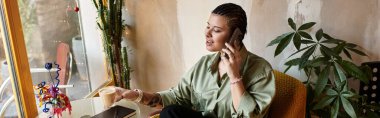 Genç bir kadın açık yeşil bir kafede kahve yudumluyor, telefonuyla sohbet ediyor..