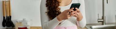 Parlak bir mutfakta, telefon konuşmasına dalmış genç bir kadın neşeli anlar paylaşır..