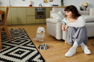 Genç bir kadın, sevimli köpeğiyle cazibeyle dolu sıcak ve davetkar bir yaşam alanında bağ kurar..