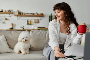 Genç bir kadın şık bir yerde kahvesini yudumluyor, köpeği yakınlarda, neşe saçıyor..
