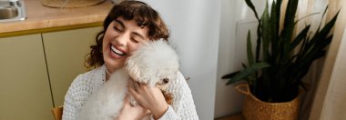 Genç bir kadın, mutfaktaki bitkilerle çevrili sevimli köpeğiyle iç açıcı bir anın tadını çıkarıyor..