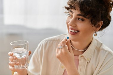 Parlak güneş ışığı odayı suyla vitamin alırken gülümseyen genç bir kadın gibi dolduruyor..