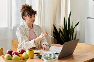 Parlak güneş ışığı, genç bir kadının, meyvelerle çevrili laptopuyla meşgul olduğu rahat bir odayı dolduruyor..