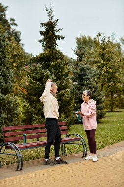 Sevgi dolu bir çift ağaçlarla çevrili güzel bir parkta neşeli bir sohbeti paylaşıyor..