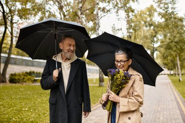 Bir çift birbirine eşlik etmekten hoşlanır, şemsiyelerin altında yürümekten, güzellik içinde..