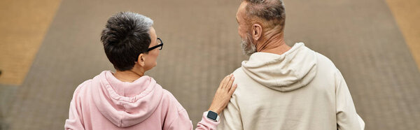 A loving couple strolls closely, sharing quiet moments filled with warmth and affection.