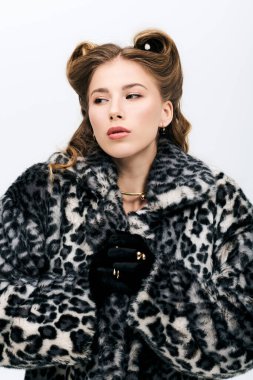 Kendine güvenen genç bir kadın şık bir leopar desenli ceketle şık bir ortamda poz veriyor..