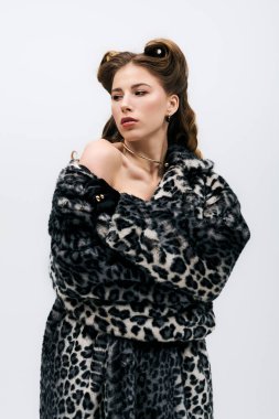 Kendine güvenen genç bir kadın şık leopar desenli bir moda sergiliyor..