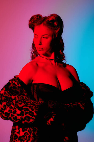 Яркие цвета окружают стильную молодую женщину, демонстрирующую свой шикарный наряд и уверенную позу.